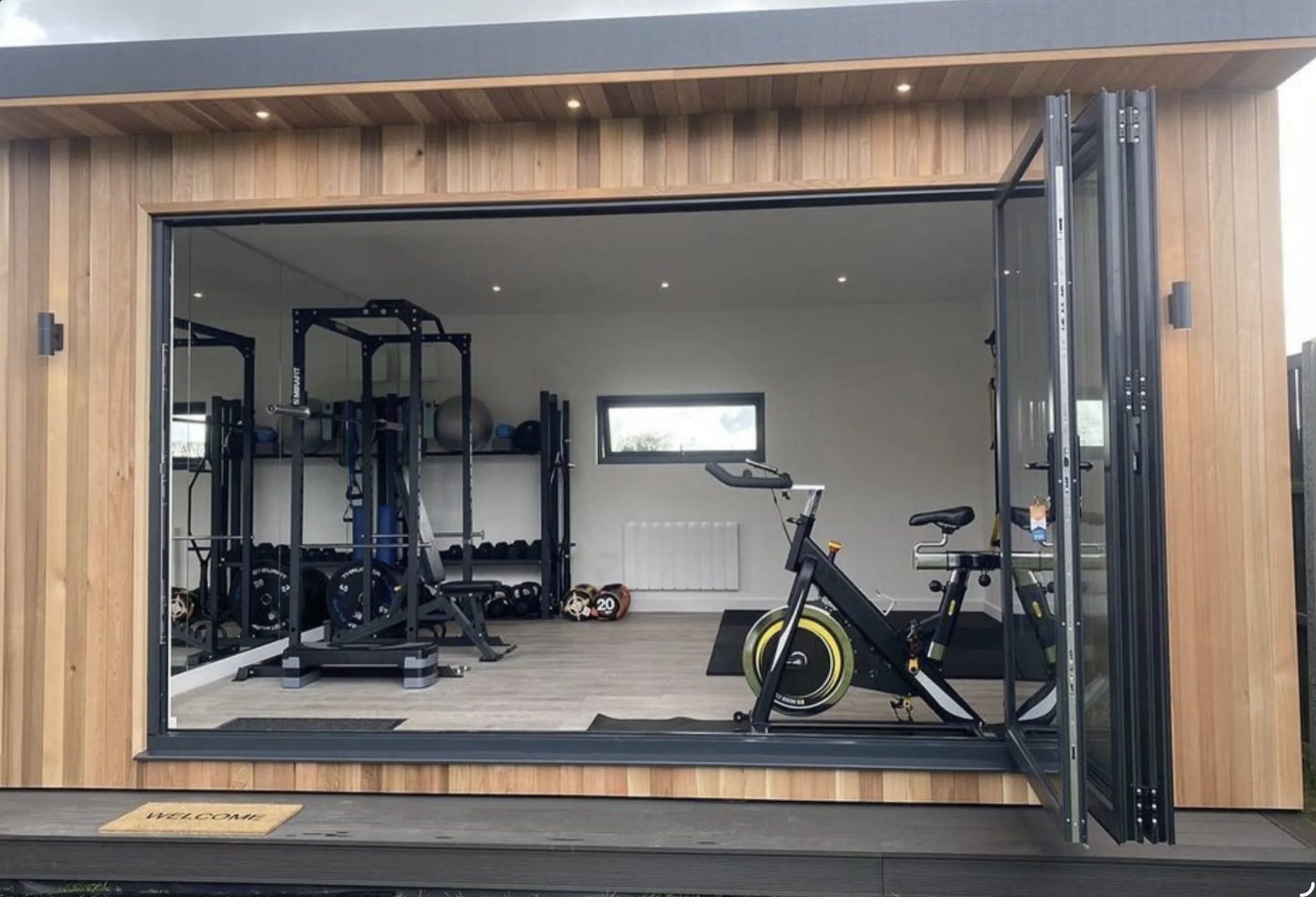 Backyard home gym with cedar cladding and open bifold glass doors